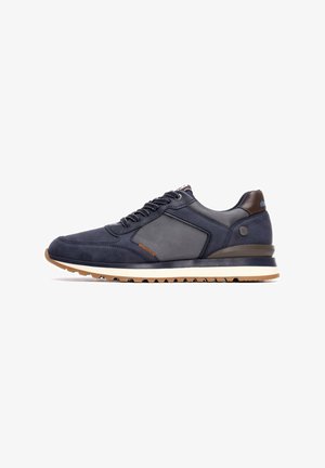 Zapatillas deportivas de color azul marino que combinan materiales de ante y malla, diseño con cordones y una suela de goma color marrón claro en contraste.