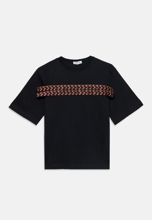 Sort kortærmet t-shirt med rund hals og et vandret mønstret vævet bånd over brystet i røde, beige og brune nuancer.