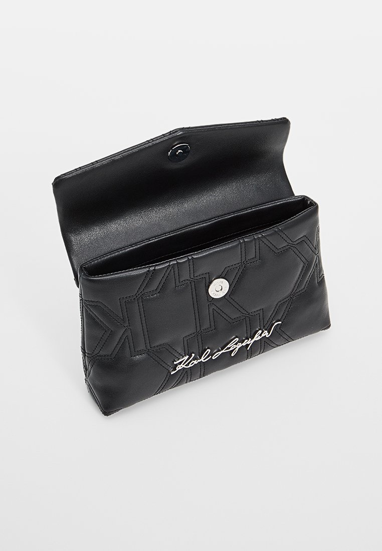 Clutch in pelle nera con design geometricamente trapuntato, chiusura a pressione in argento e logo ricamato sul davanti. L'interno è liscio e semplice.