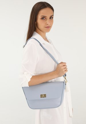 Lys blå læder crossbody taske med flaplukning og guldfarvet hardware. Har en aftagelig rem og en tekstureret overflade.