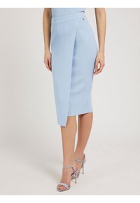 Hellblaue gerippte Bleistiftrock mit Wickeldesign, ausgestattet mit einem Seitenschlitz und einer glatten Textur. Kombiniert mit passenden High-Heels.