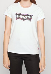 Biały bawełniany T-shirt z kolorowym logo Levi's w kształcie łuku umieszczonym na środku klatki piersiowej. Krótkie rękawy i okrągły dekolt.