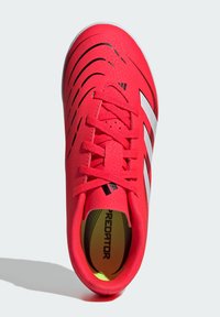 Scarpa da calcio rossa con strisce nere, tomaia in sintetico texturizzato, punta rotonda, chiusura con lacci, marchio bianco e rivestimento interno neon.