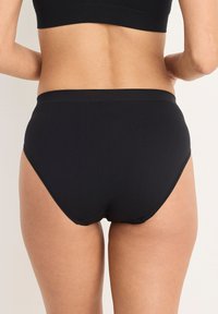 Svart underkläder med hög midja, sömlös design och en mjuk, stretchig textur. En enkel stil som passar för vardagsbruk.