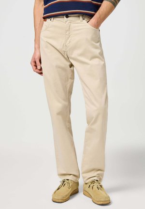 Pantalones de algodón beige con un corte recto clásico, que cuentan con dos bolsillos delanteros, cierre de botón y detalles de costura sutiles.