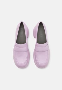 Paire de mocassins en cuir violet pastel avec bouts ronds, talons bas et design sans lacets sur fond blanc.