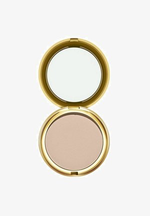 Pieni beige puuteripuuteri avoimessa, pyöreässä kultaisessa rasiassa, jossa kannen sisäpuolella on peili, valkoista taustaa vasten.