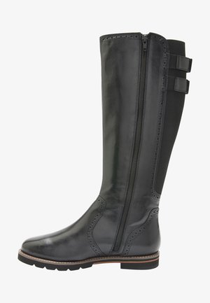 Stivali neri in pelle al ginocchio con cerniera frontale, dettagli brogue, pannelli laterali testurizzati e suola in gomma con tacco basso.