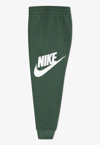 Pantalones de chándal verdes de Nike con cintura elástica, piernas ajustadas y un gran logo blanco de Nike en el lateral. Tejido suave con una textura lisa.