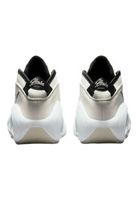 Sko med överdel i vitt läder, kontrasterande svarta detaljer, vadderad krage och en tjock vit sula med texturerad yta.