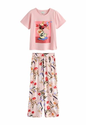 Cămașă roz deschis cu mâneci scurte cu imprimeu cu vază florală, asortată cu pantaloni roz deschis cu croială largă și modele florale roșii, violete și verzi.