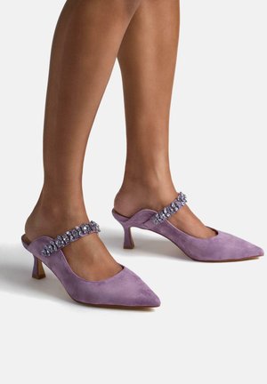 Lavender suede mules with pointed toes and a mid-height heel, featuring a decorative strap embellished with clear gemstones.