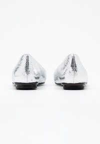 Stříbrné metalické baleríny s texturovaným povrchem, špičatou špičkou a nízkým černým podpatkem; hladký povrch s motivem ještěří kůže.