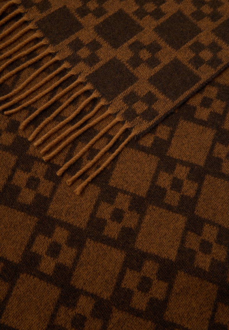 Braun gemusterter Schal mit quadratischem Design und fransigen Kanten, aus weichem Wollmaterial gefertigt, das verschiedene Brauntöne zeigt.