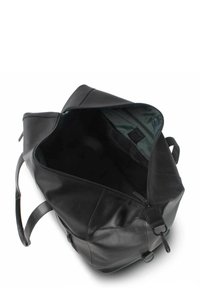Zwarte leren tas met een ritssluitingen, gladde buitenkant en een ruime binnenkant met een groene voering en minimale hardware.