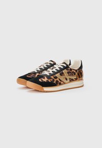Et par low-top sneakers med leopardmønster, sorte ruskindsdetaljer, hvide snørebånd og beige såler på en hvid baggrund.