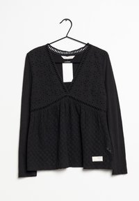 Maglietta nera a maniche lunghe con scollatura a V, caratterizzata da un corpo tessuto simile a pizzo e orlo svasato. Include dettagli decorativi a maglia e un'etichetta.