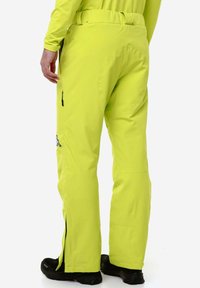 Pantaloni impermeabili gialli brillanti con taglio dritto, dotati di cerniere laterali, passanti per cintura e cuciture rinforzate per una maggiore durata.