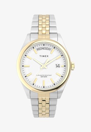 Strieborné a zlaté kovové náramkové hodinky s bielym ciferníkom, zlatými hodinovými značkami, zobrazením dátumu a indikátorom "Streda". Vodoodolné do hĺbky 50 m.