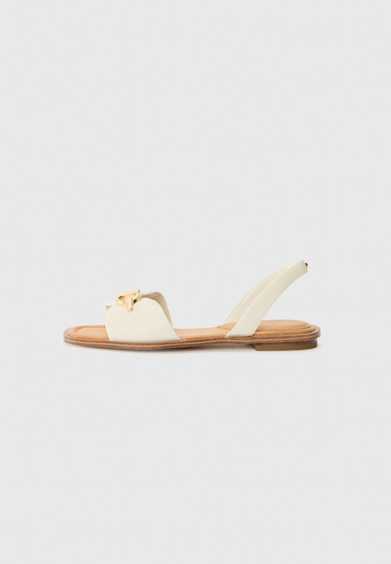 Kremfargede flate sandaler med rund tå, en gullspenne som accent, og en teksturert tan fotseng. Har design med slingback-stropp.