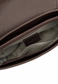 Brown leather bag interior with a textured surface, featuring a zippered compartment and a soft gray lining. Label visible inside.