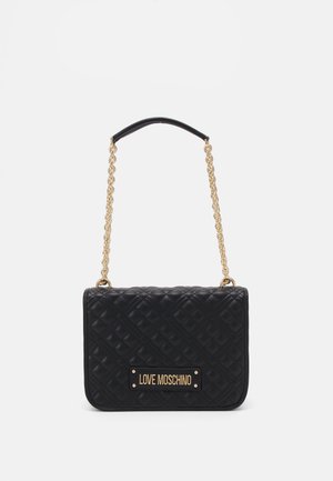 Svart vadderad handväska med ett guld chain-handtag, med en märkesskylt i guld på framsidan och rektangulär form med mjuk textur.