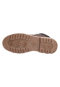 Las suelas de goma marrón de Dockers cuentan con patrones de relieve prominentes, acentos texturizados y un logotipo en relieve, diseñadas para ofrecer tracción y estabilidad.