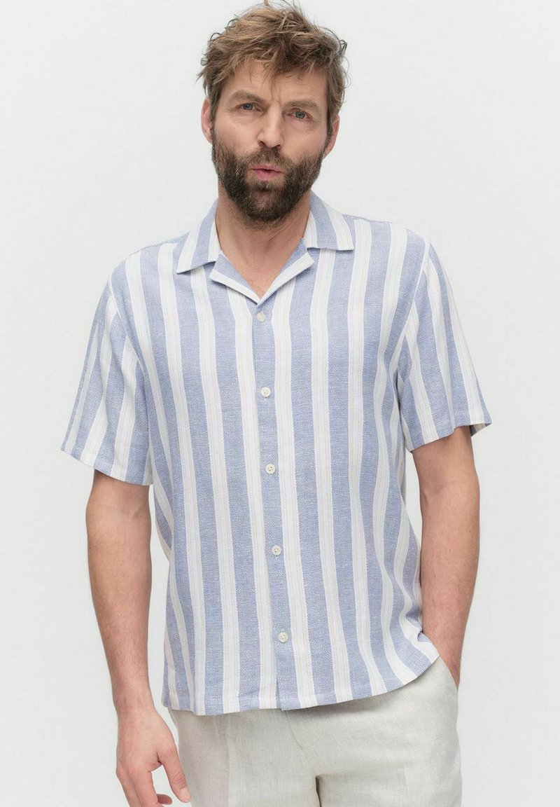 Chemise à manches courtes rayée bleu et blanc, confectionnée en tissu texturé avec un col camp et cinq boutons sur le devant.