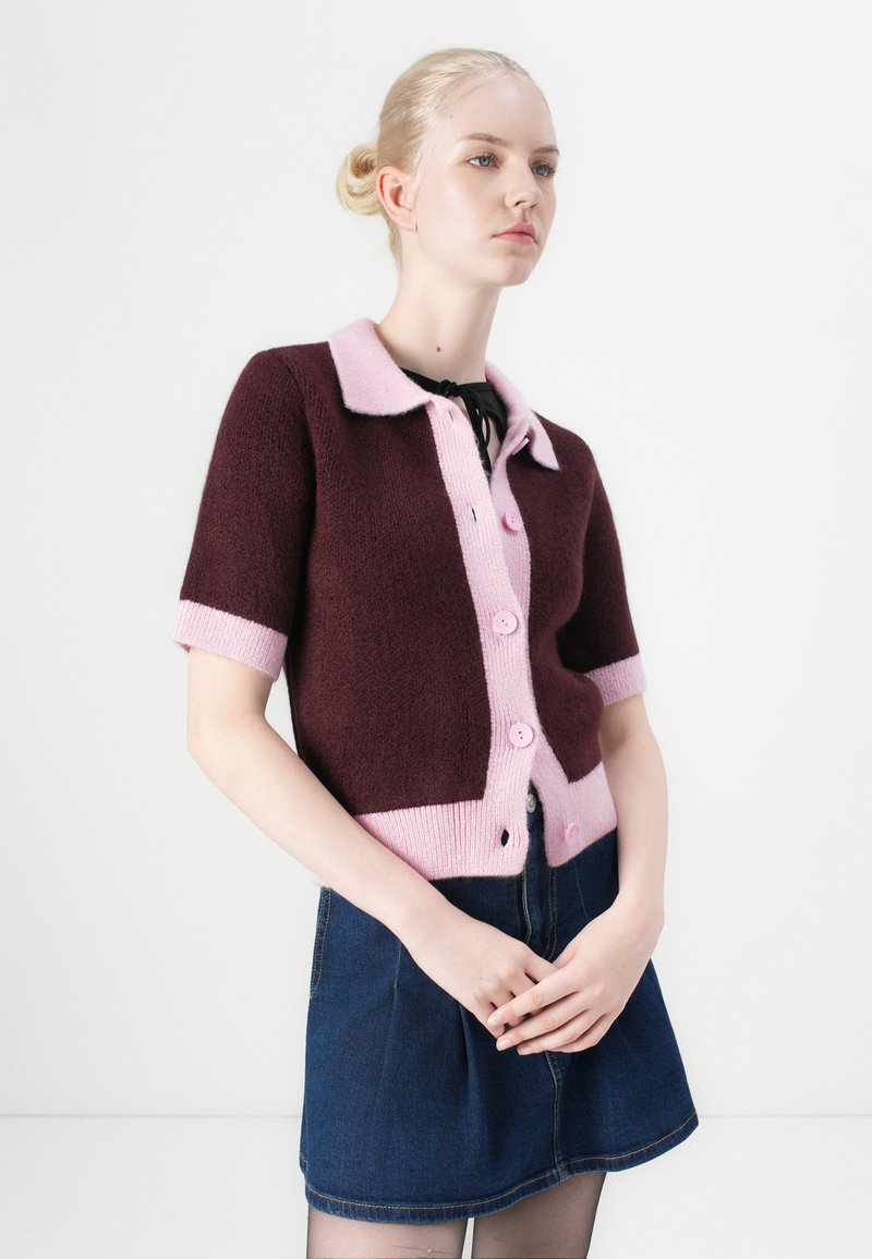 Korte mouw sweater in bordeaux en roze met een kraaghals, voorzien van een knopenfront en contrasterende ribgebreide manchetten.