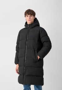 Black puffer coat with a hood, featuring quilted design, front zipper, and side pockets. Material appears smooth and insulated.