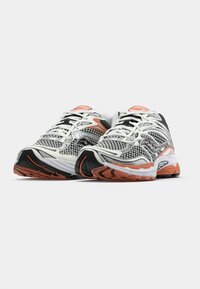 Running shoes featuring a mesh upper in black and white with orange accents, a cushioned sole, and textured tread for grip.