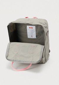 Γκρι σακίδιο με ροζ λαβή, διαθέτει μπροστινή τσέπη με καπάκι και εσωτερική ετικέτα. Ομαλή υφή, απλός σχεδιασμός και στρογγυλεμένο σχήμα.