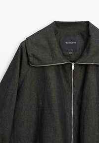 Donkergrijs jack met ritssluiting en brede kraag, gemaakt van gestructureerde stof, met een zichtbare zilveren ritssluiting en een Massimo Dutti-label aan de binnenkant van de kraag.