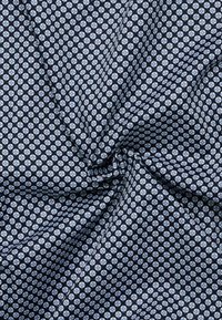 Marine stoffen met een herhalend geometrisch patroon in lichtblauw en wit, met een gladde textuur en een zachte val.