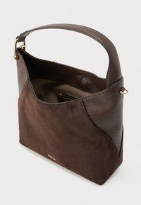 Brūna zamšādas un ādas rokassoma ar platu rokturi, atvērts augšējais vāks, kas parāda iekšējo rāvējslēdzēja kabatu un zelta detaļas.