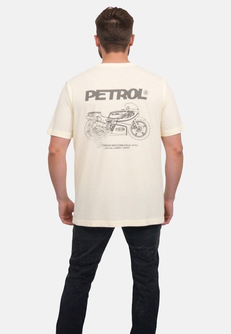Crèmefarvet bomulds T-shirt med et grafisk design af en motorcykel på ryggen, med ordet "PETROL" i fede bogstaver ovenfor.