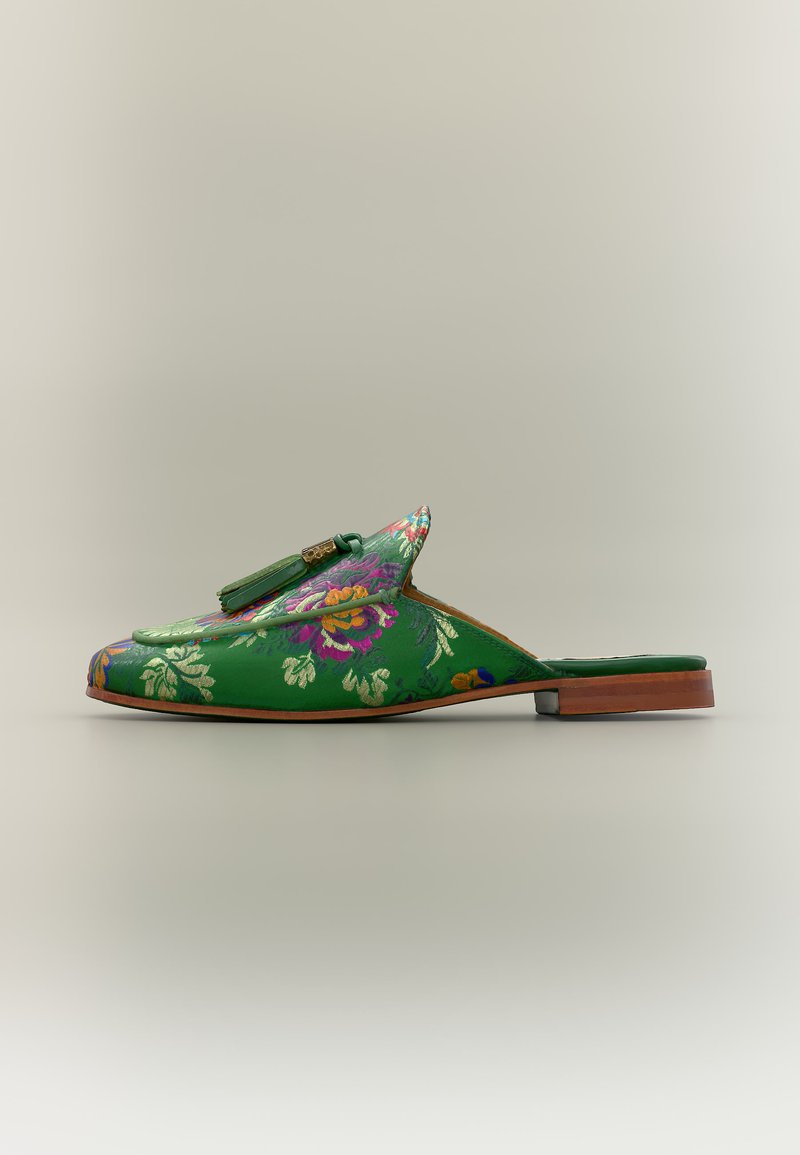 Πράσινο λουστρίνι μοκασίνι χωρίς κορδόνια με διακοσμητική φούντα και χαμηλό ξύλινο τακούνι, απεικονίζεται σε πλαϊνή όψη σε ανοιχτό φόντο.