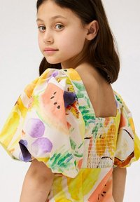 Korsetti värikkäällä kukkakuviolla, jossa on keltaisen, violetin ja oranssin sävyjä. Siinä on pullistuvat hihat ja neliömäinen selkädesign.