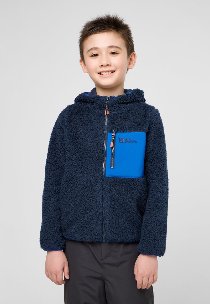 Veste en polaire zippée de couleur bleu marine avec des accents bleus, surface texturée, capuche et poche poitrine zippée.
