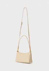 Sac bandoulière en cuir marron clair avec une forme incurvée, un accent en chaîne dorée et une sangle ajustable, présentant une texture lisse et un design minimaliste.