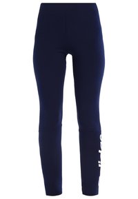 Marinblå leggings med hög midja och vit text som delvis är synlig på det nedre högra benet mot en vit bakgrund.