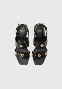 Sandali slingback neri in pelle con doppie cinghie decorate con dettagli floreali dorati e hardware circolare. Design con punta quadrata.
