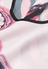 Tissu à motifs avec des volutes abstraites en nuances de rose, bleu et blanc, bordé d'un galon noir le long de l'encolure. Texture lisse.