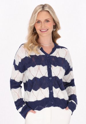 Pletený cardigan s vzorem ve tvaru písmene V v námořnické modré a bílé barvě. Kulatý výstřih, zapínání na knoflíky, texturovaná látka a žebrované manžety.