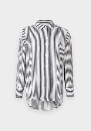 Camicia bianca con strisce verticali blu navy, chiusura a bottoni frontale, colletto a punta, maniche lunghe e orlo leggermente curvato per una vestibilità rilassata.