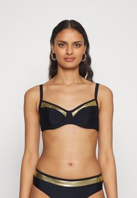 Juodas bikini viršus su auksinėmis detalėmis, pasižymintis struktūrizuotu kirpimu, reguliuojamomis petnešėlėmis ir lygiu paviršiumi. Suderinamos kelnaitės su auksine juostele.