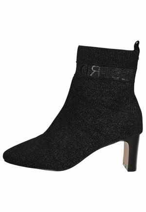 Stiefelette mit spitzem Zeh, aus strukturiertem schwarzem Stoff, mit einem gerippten Bündchen und einem kleinen Blockabsatz. Logo-Band am Bündchen.