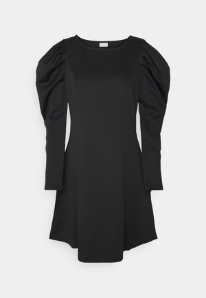 Robe noire à manches longues avec épaules bouffantes, taille ajustée et encolure bateau, présentée sur un fond blanc uni.