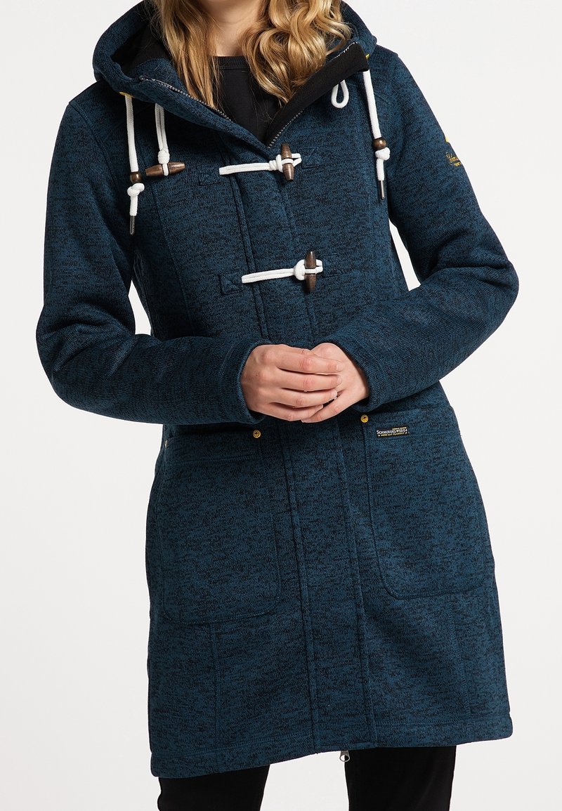 Mörkblå lång kappa i texturerad kvalitet, med vita snören och träpluggar, framfickor och huva.