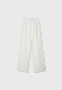 Pantalons larges blancs avec une taille à cordon, fabriqués en tissu léger. Texture douce avec poches latérales et silhouette décontractée.